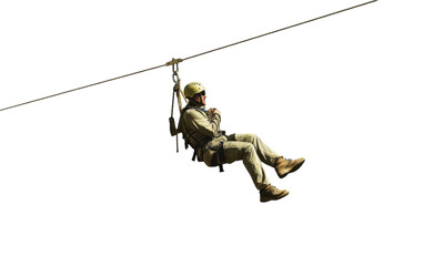 A soldier hangs from a rope, navigating a zip line across a thrilling terrain