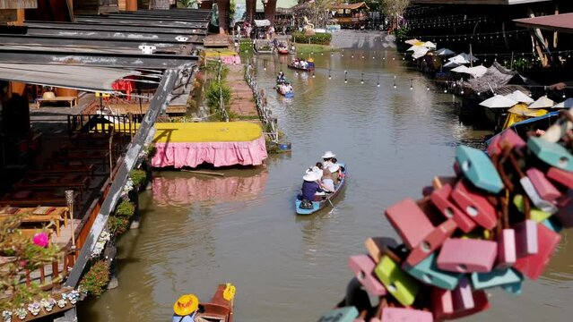 PATTAYA, THAILAND, DECEMBER 16, 2017: Pattaya Floating Market. Small Tourist Wooden Boat with the Chinese are moving along the water. A popular place for tourists. Old Thai style and Vintage Market of