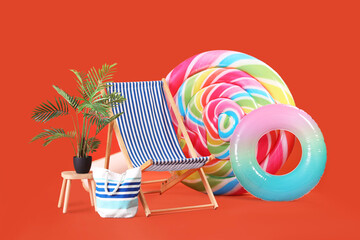 Swimming mattress in shape of candy, inflatable ring and sun lounger on orange background