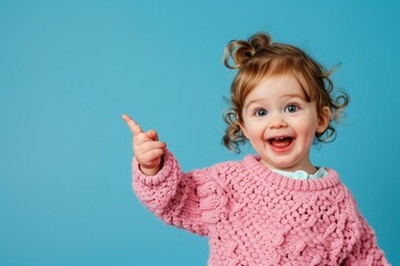 adorable little toddler pointing hr finger at something in pink knitted sweater 