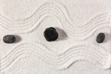 Stones on sand with lines in Japanese rock garden, top view.  Zen concept