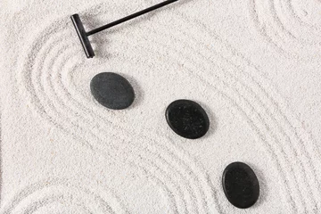 Tuinposter Rake and stones on sand with lines in Japanese rock garden. Zen concept © Pixel-Shot