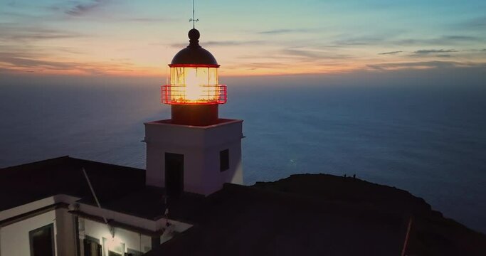 Aerial view to working lighthouse at dusk time located on a picturesque rock. Lighthouse Ponta do Pargo, Madeira Portugal