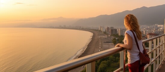 Female caucasian tourist enjoy Panoramic View of Batumi coast and tourist attractions with romantic sunset background. - obrazy, fototapety, plakaty