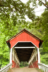 Fototapeta na wymiar Covered bridge in summer surrounded by lush foliage