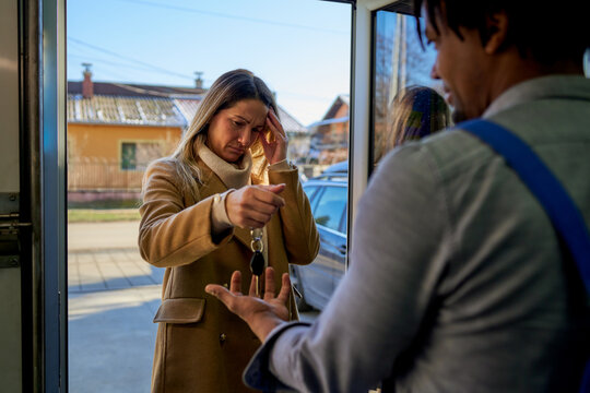 A worried customer delivers car keys to the mechanic at the workshop door, a moment reflecting concern and reliance on expert service. - Powered by Adobe