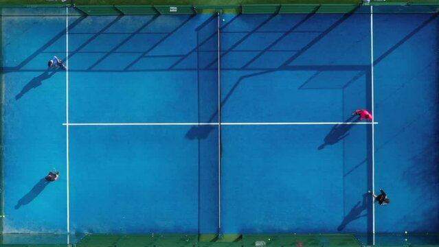 Paddle tennis court: Aerial view of unrecognizable tennis athletes seen from above playing a game of paddle tennis at an outdoor padel tennis court