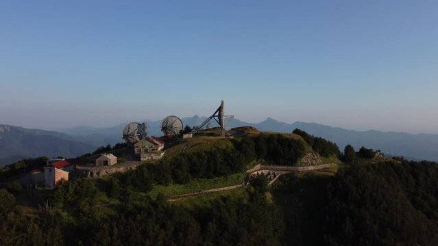 Aerial view of the big parabolic antenna of the NATO radio station abandoned on the top of Monte Giogo, used during cold war. Comano, Massa and Carrara province, Lagastrello lake, Tuscany, Italy. 