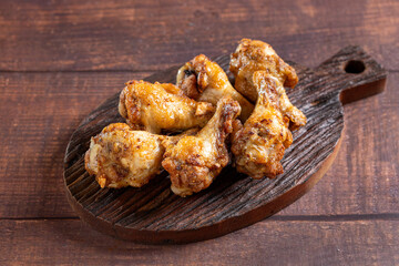 Grilled chicken drumette on cutting board.