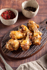 Grilled chicken drumette on cutting board.