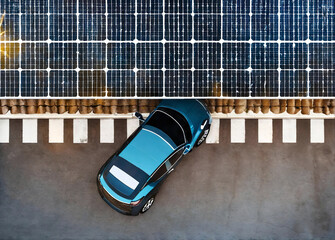 Aerial view directly above electric cars parking under solar panels on a parking lot rooftop ready for charging in an innovative technology concept.  electric car parking in charging station