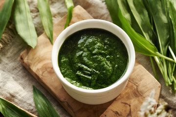 Homemade green pesto sauce made from fresh wild garlic leaves - a wild edible plant harvested in...