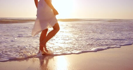 Woman, walking and beach at sunset in water for relax explore on tropical island for wellness, adventure or holiday. Female person, spin and sea vacation for ocean travel for resting, calm or trip