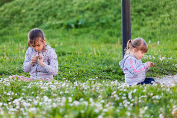 Due bambine si divertono a raccogliere i fiori in primavera