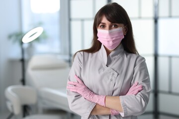 Cosmetologist in medical uniform in clinic, space for text