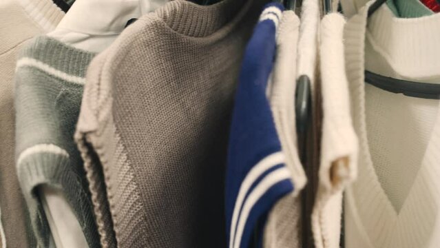 Sweaters in various colors, sizes, and styles hang neatly on a rack, creating a visually appealing display.