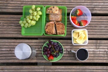 well-arranged assortment of food items on wooden surface, outdoor picnic. concepts: healthy eating,...
