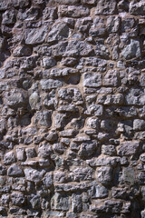 Old beige stone wall background texture close up