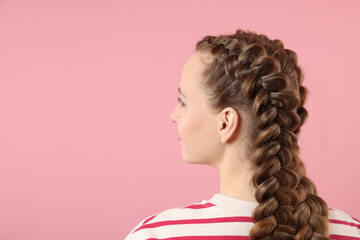 Woman with braided hair on pink background, space for text - obrazy, fototapety, plakaty