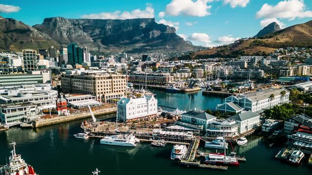 Aerial drone hyperlapse view of Bustling Victoria and Alfred Waterfront in Cape Town, South Africa on a Clear Day with Table Mountain and CBD Cape Town in background