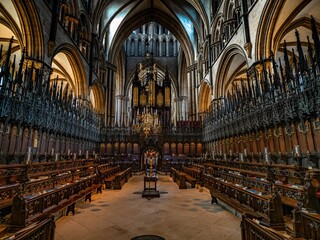 Fototapeta premium Lincoln Cathedral, Roman Catholic Gothic church and cathedral with stain glass window corridor and hall, with arches, columns, pews, vault, aisles, gallery, arcades and clerestory.