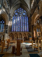 Fototapeta premium Lincoln Cathedral, Roman Catholic Gothic church and cathedral with stain glass window corridor and hall, with arches, columns, pews, vault, aisles, gallery, arcades and clerestory.