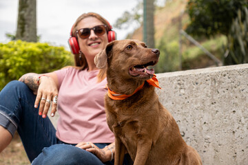 Portrait of a dog looking to the side while sitting next to its smiling owner.