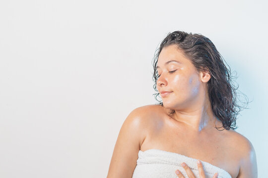Mujer morena con cabello mojado saliendo de la ducha