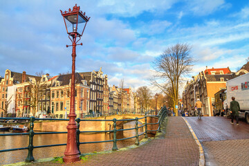 Cityscape on a sunny winter day - view of the canal embankment with bridges in the historic center of Amsterdam, The Netherlands