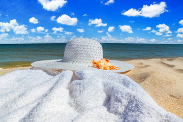 Close-up view of a sun hat on a sandy beach by the sea, selective focus. Beach holiday concept, background with copy space for text