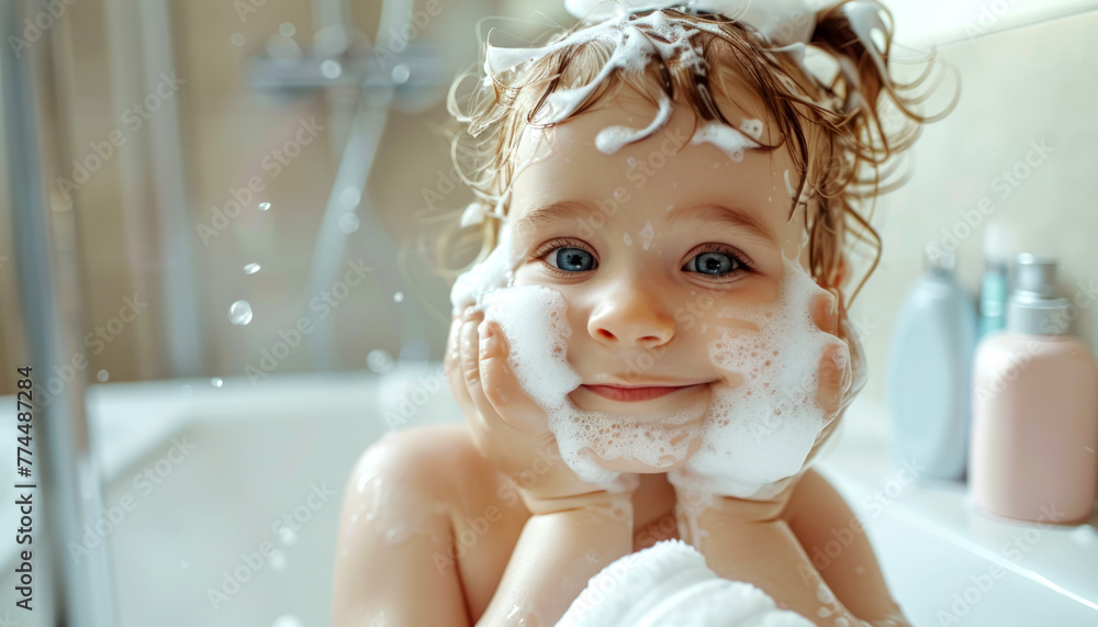 Wall mural Cute smiling toddler taking a bath and applies soft foam on face in bathroom