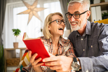 mature senior couple man and woman husband and wife read book at home