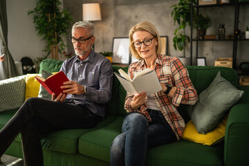 mature senior couple man and woman husband and wife read book at home