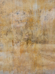 Texture of yellow marble with veins on the wall of an aged exterior facade in a city