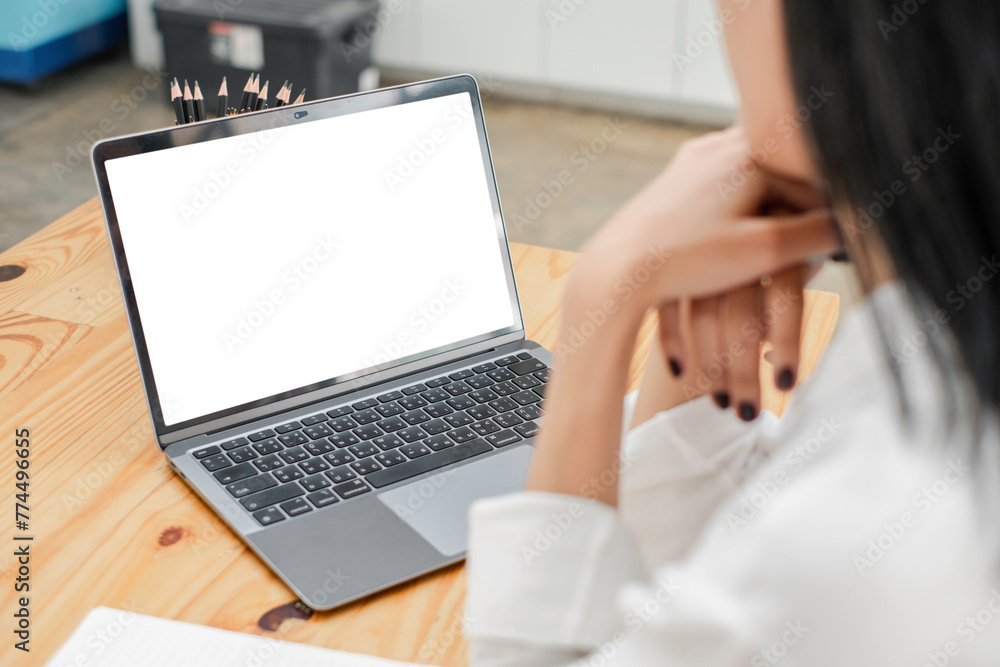 Poster close-up back view of a business woman working in the office typing, looking at the screen. office w
