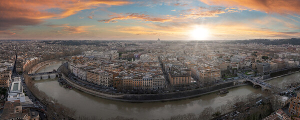 Panoramic view of Rome at sunset with the Tiber River winding through, reflecting the sunset's warm...