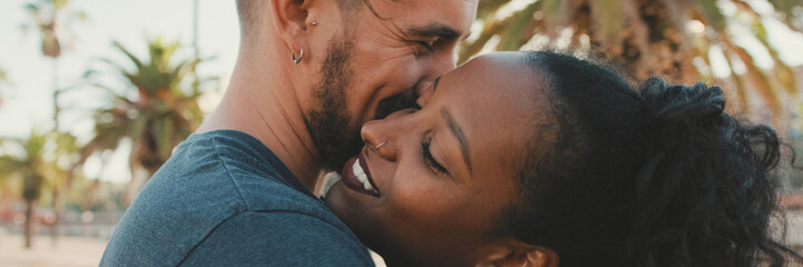 Close up, happy interracial family kisses outside, Panorama