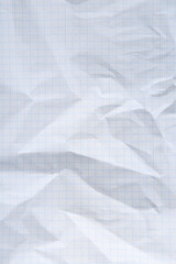 Crumpled checkered notebook sheet as background, top view