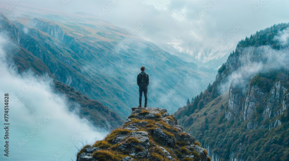 Poster man standing on the edge of a cliff with fog in the background