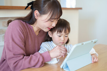 タブレットで絵を描く女の子とお母さん