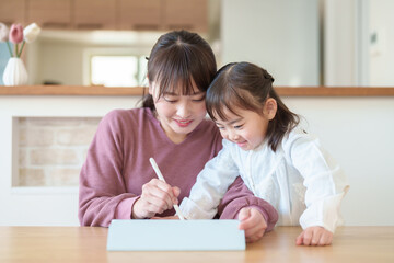 タブレットで絵を描く女の子とお母さん