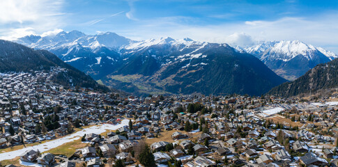 Aerial panoramic view of Verbier, Switzerland, showcasing a mix of snow covered and green...