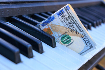 A keyboard with a dollar bill on it