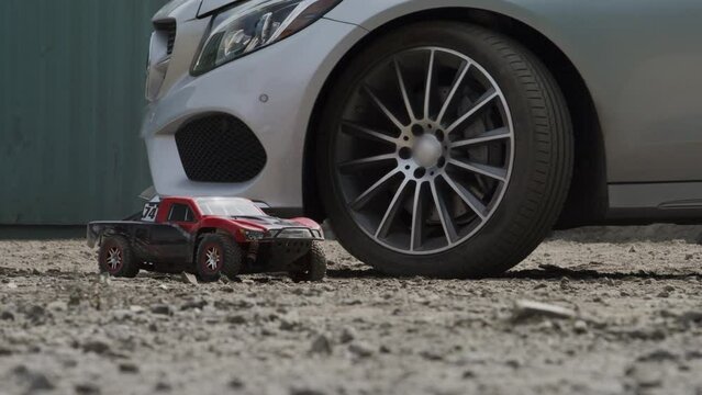 Epic RC car kicking up dust next to vehicle - cinematic slow motion