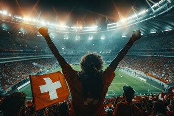 A woman is holding a flag in a stadium full of people. Football fan at the football championship