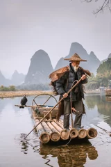 Papier Peint photo autocollant Guilin A traditional cormorant fisherman works on the Li River Yangshuo, China.