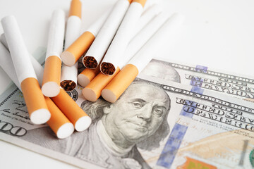Cigarette on US dollar banknotes, cost, trading, marketing and production, No smoking concept.