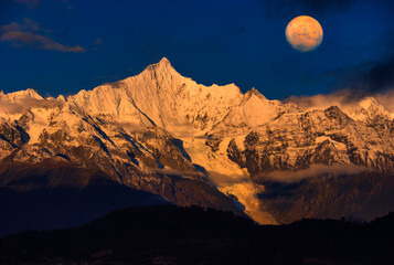 梅里雪山の急峻な霊峰に満月合成