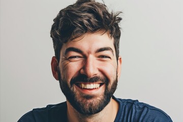 Portrait of a smiling man with a beard on a gray background