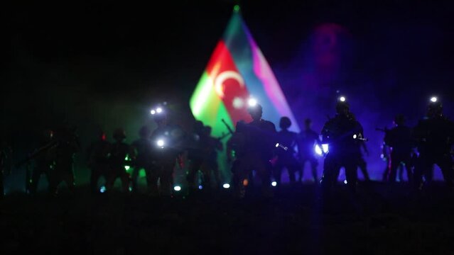Azeri army concept. Silhouette of armed soldiers against Azerbaijani flag. Creative artwork decoration. Military silhouettes fighting scene dark toned foggy background. Selective focus